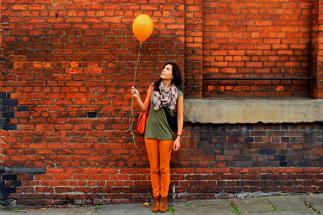 Woman holding a orange ballon
